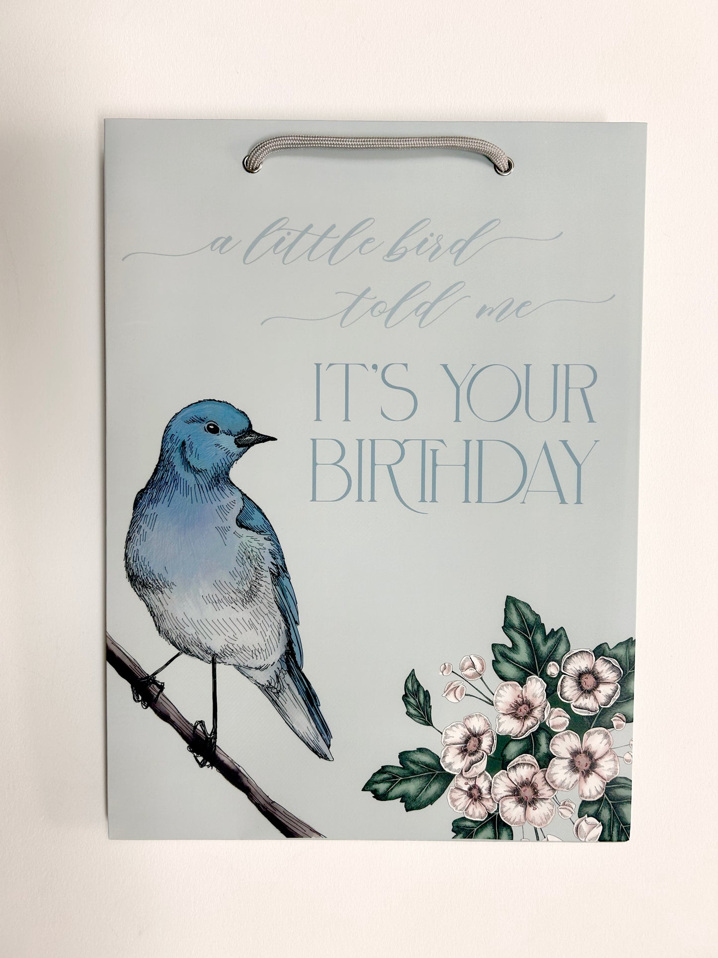 photo of flat blue gift bag with florals that reads "A little bird told me it's your birthday" by Rust Belt Love