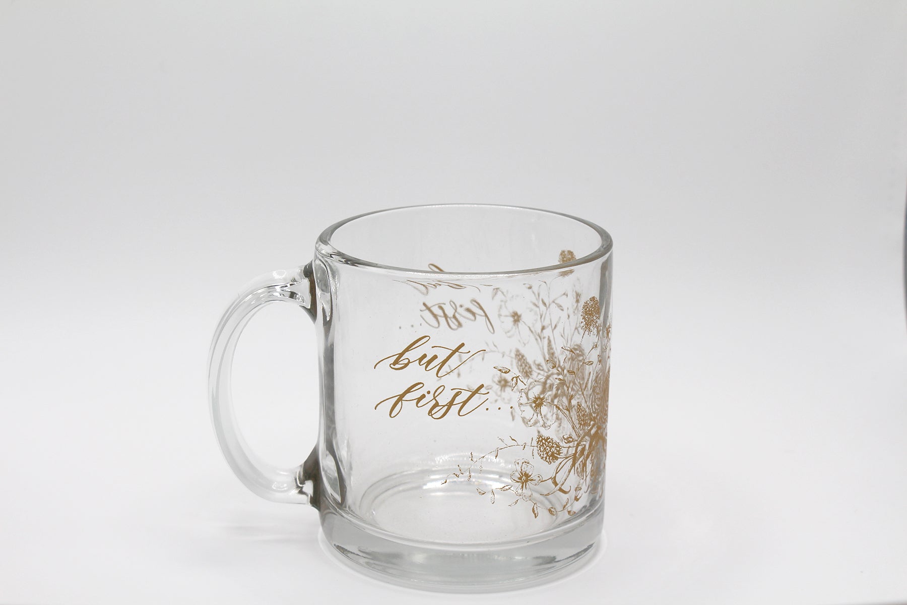 Gold ink on clear glass mug with flowers and that says "but first..." by Rust Belt Love