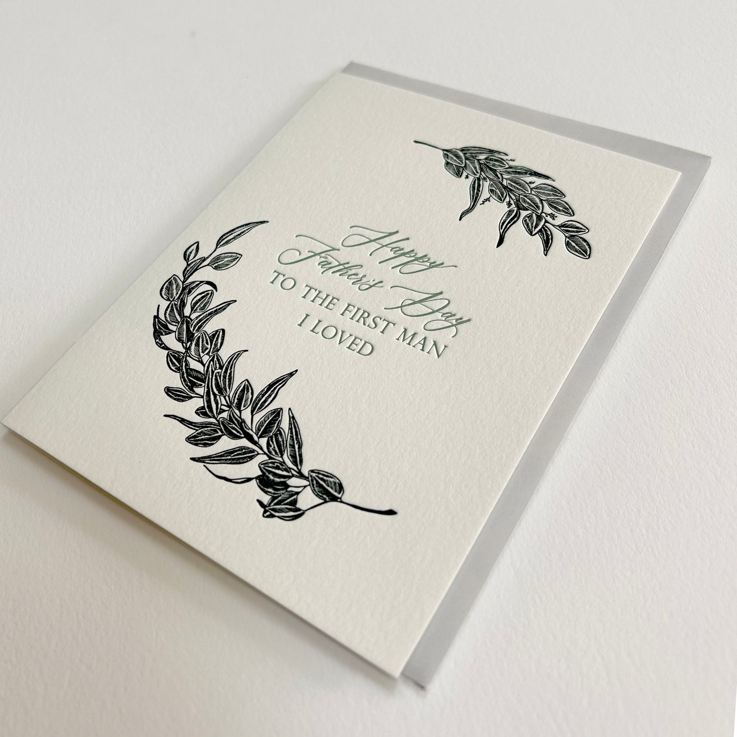 Letterpress father's day card with black greenery that reads "Happy Father's Day to the first man I loved"by Rust Belt Love