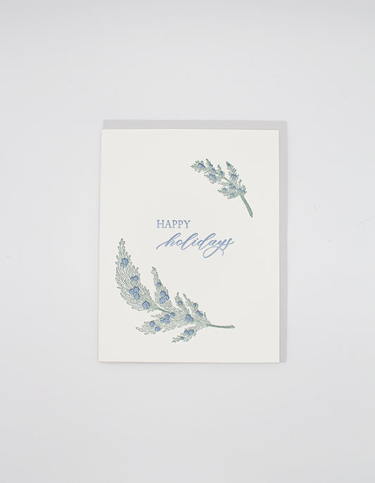 Box of letterpress holiday cards with greenery that says "Happy Holidays" by Rust Belt Love
