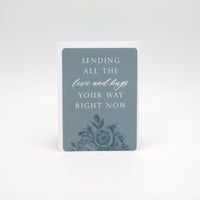 Light blue floral minicard that reads "Sending all the love and hugs your way right now" by Rust Belt Love