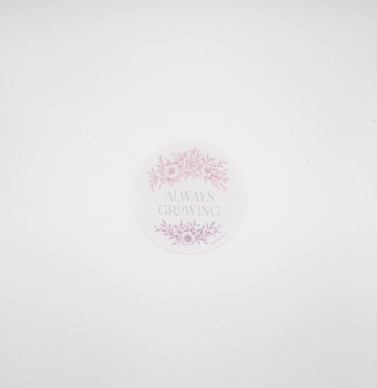 Circular pink sticker with florals that says "always growing" by Rust Belt Love