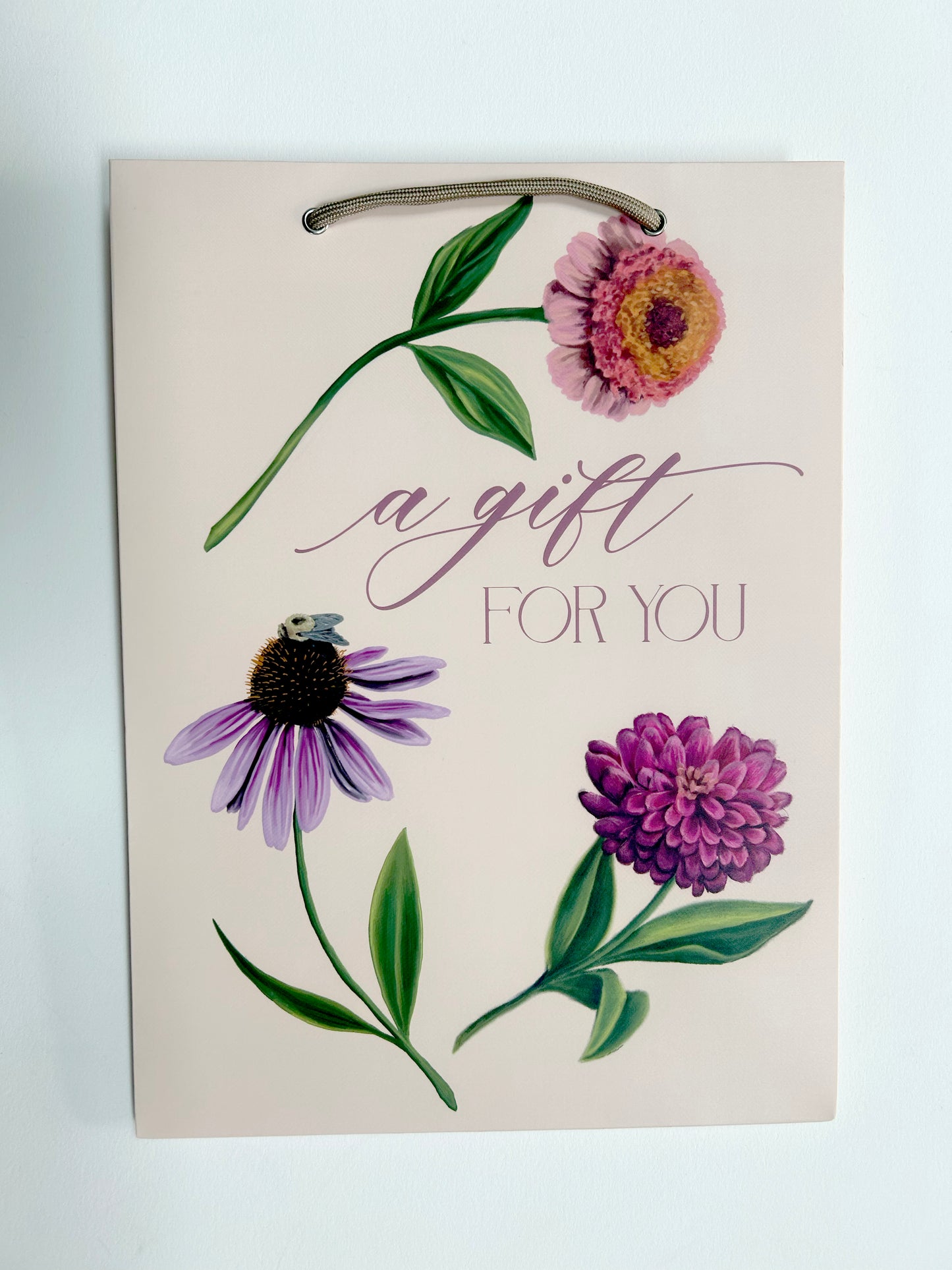 Photo of pink gift bag with florals that reads "A gift for you" by Rust Belt Love