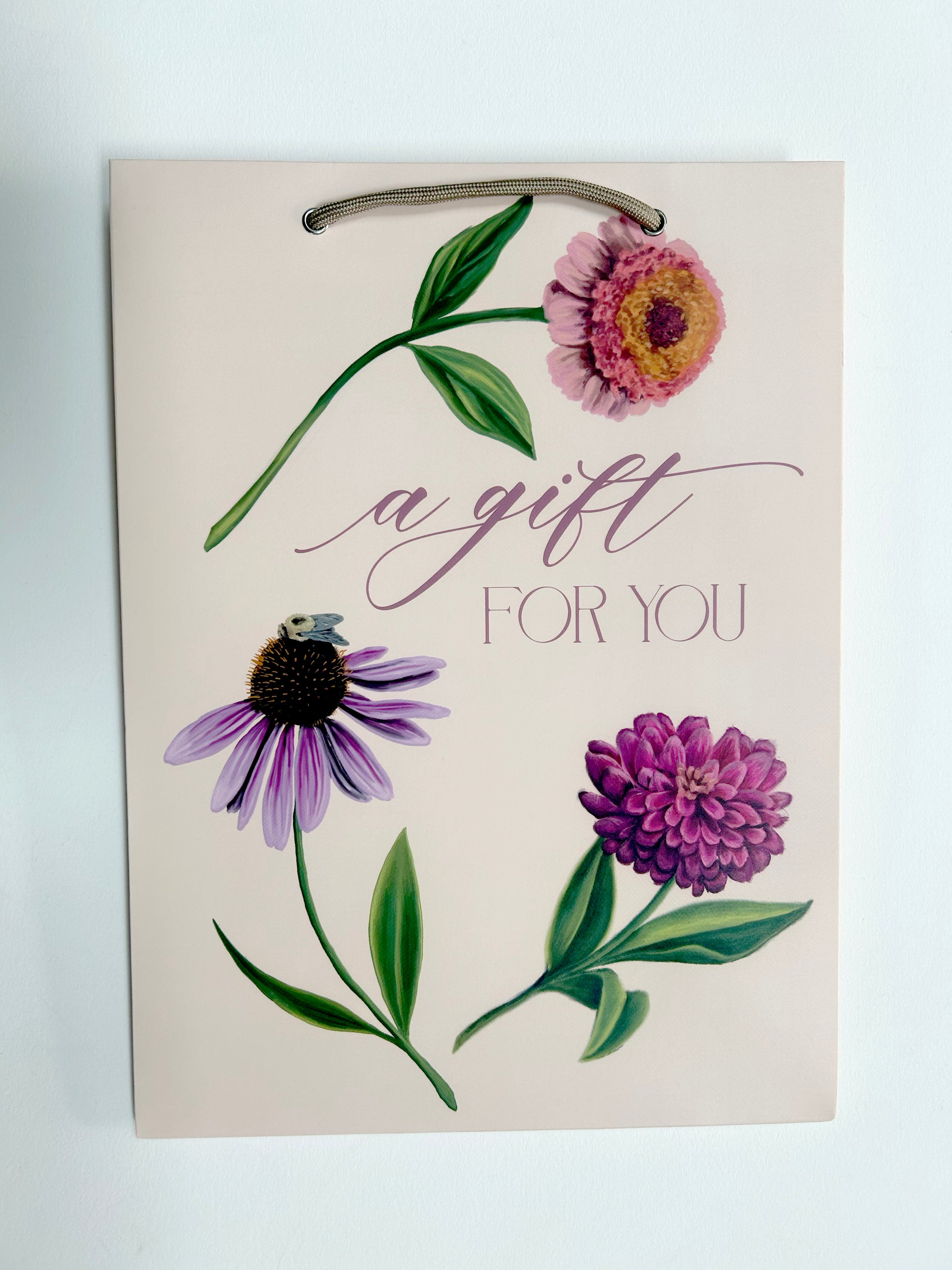 Photo of pink gift bag with florals that reads "A gift for you" by Rust Belt Love