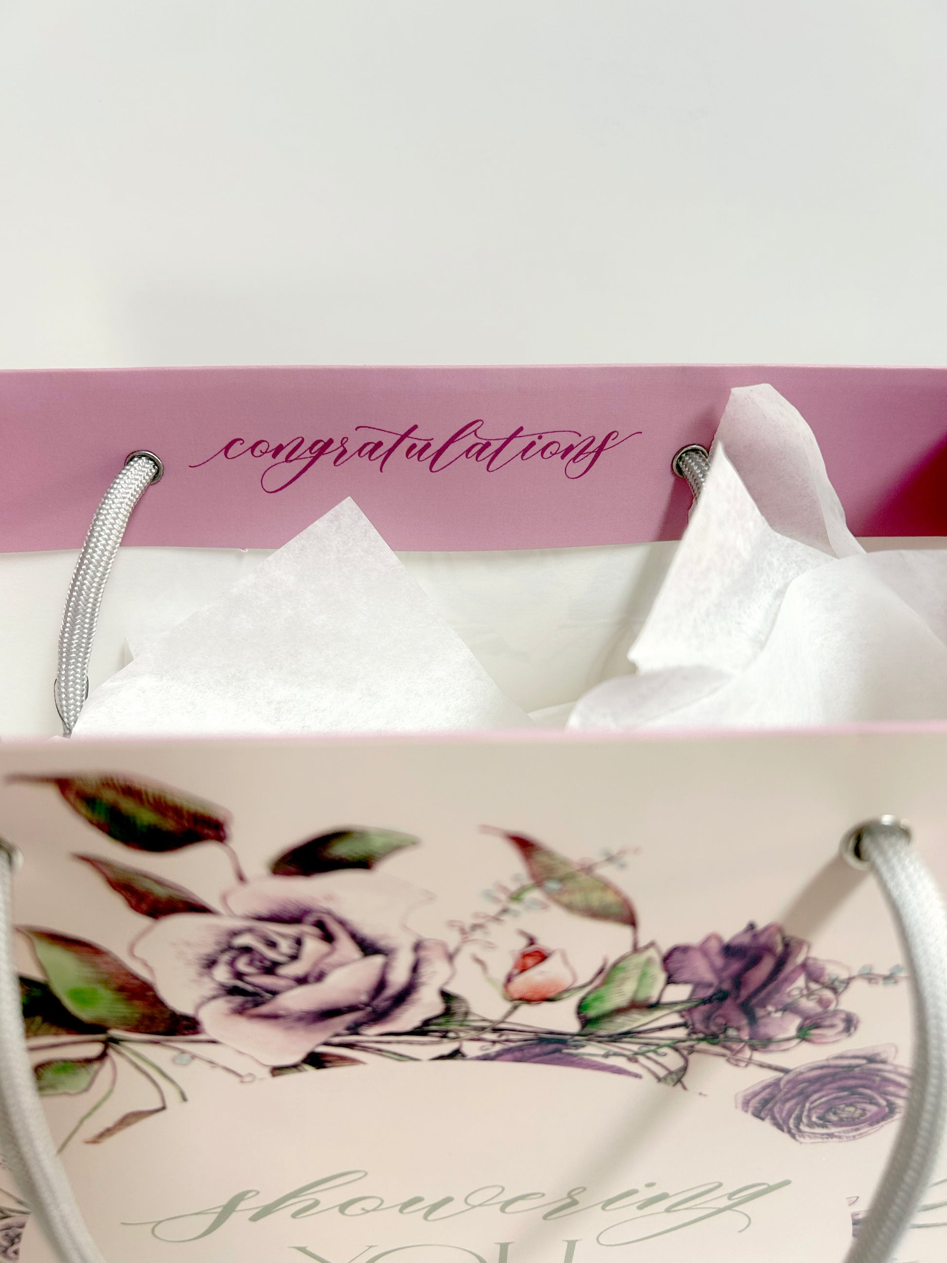 The inside lip of the pink gift bag by Rust Belt Love that reads "congratulations"