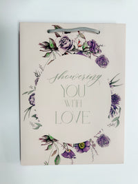 Flat pink floral gift bag that reads "Showering you with love" by Rust Belt Love