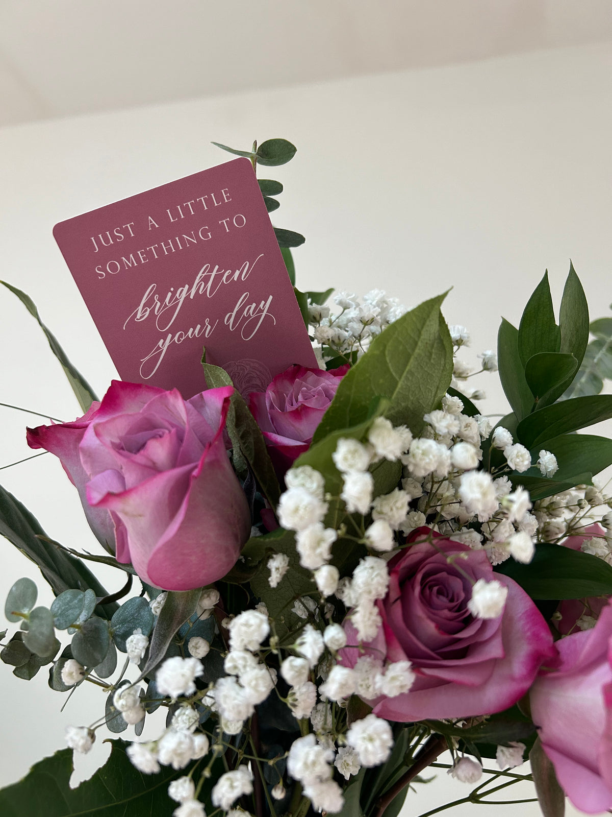 Style shot of pink minicard in a bouquet of flowers