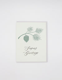 Green letterpress holiday card with branch and pinecone that reads "Season's Greetings" by Rust Belt Love