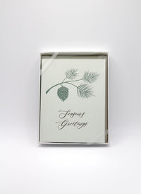 Box of green letterpress holiday cards with branch and pinecone that reads "Season's Greetings" by Rust Belt Love