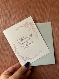Letterpress love card with florals that says "Showering you with love" by Rust Belt Love