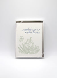Box of letterpress holiday cards with green florals that reads "wishing you a snowy solstice" by Rust Belt Love