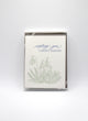 Box of letterpress holiday cards with green florals that reads "wishing you a snowy solstice" by Rust Belt Love
