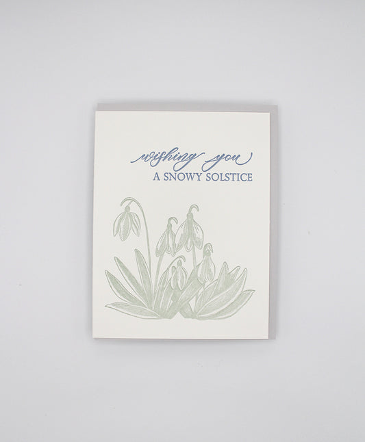 Box of letterpress holiday cards with green florals that reads "wishing you a snowy solstice" by Rust Belt Love