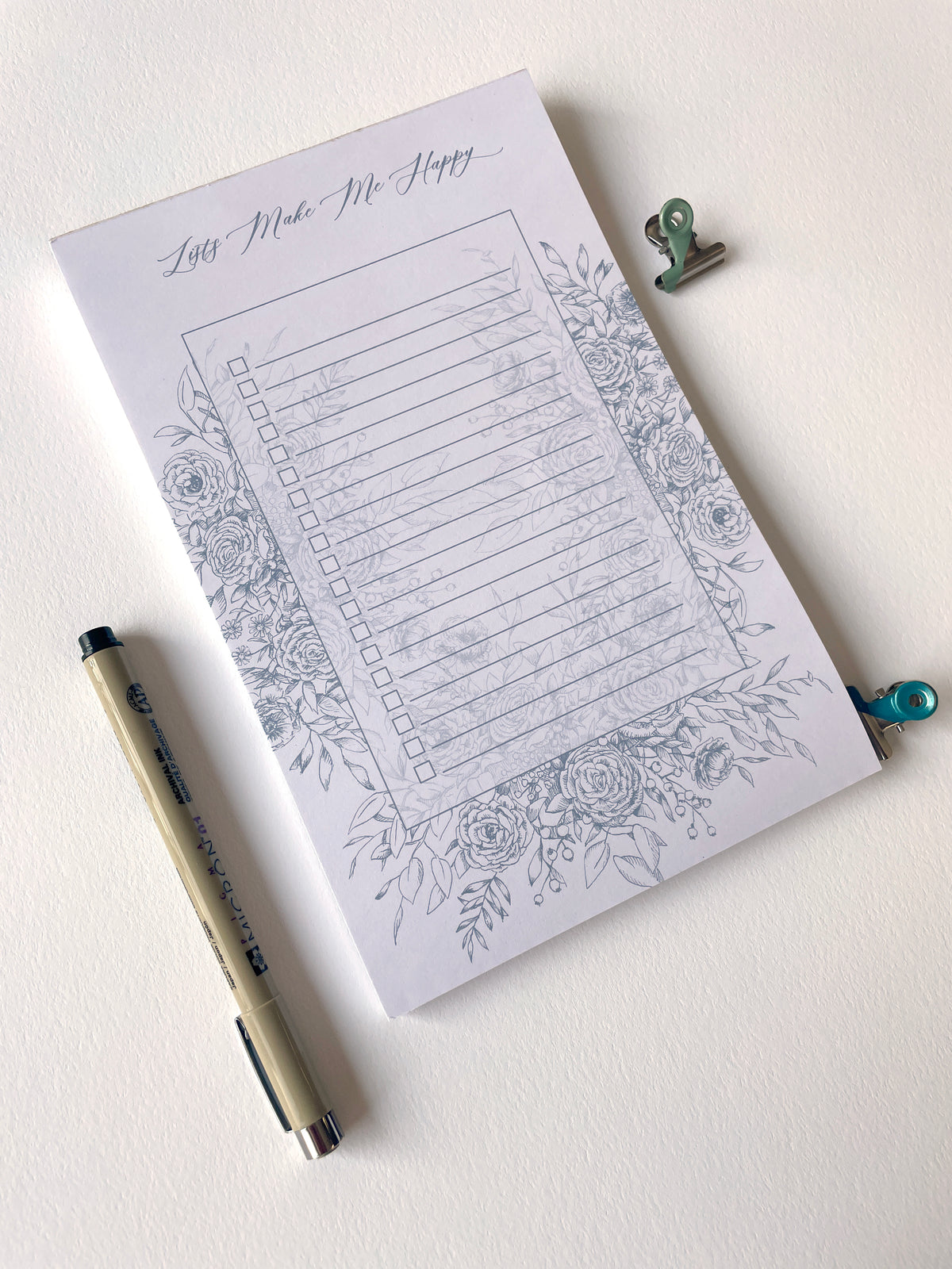 5.5 by 8.5 notepad with lined sheets with blue florals that says "Lists make me happy" by In Good Company
