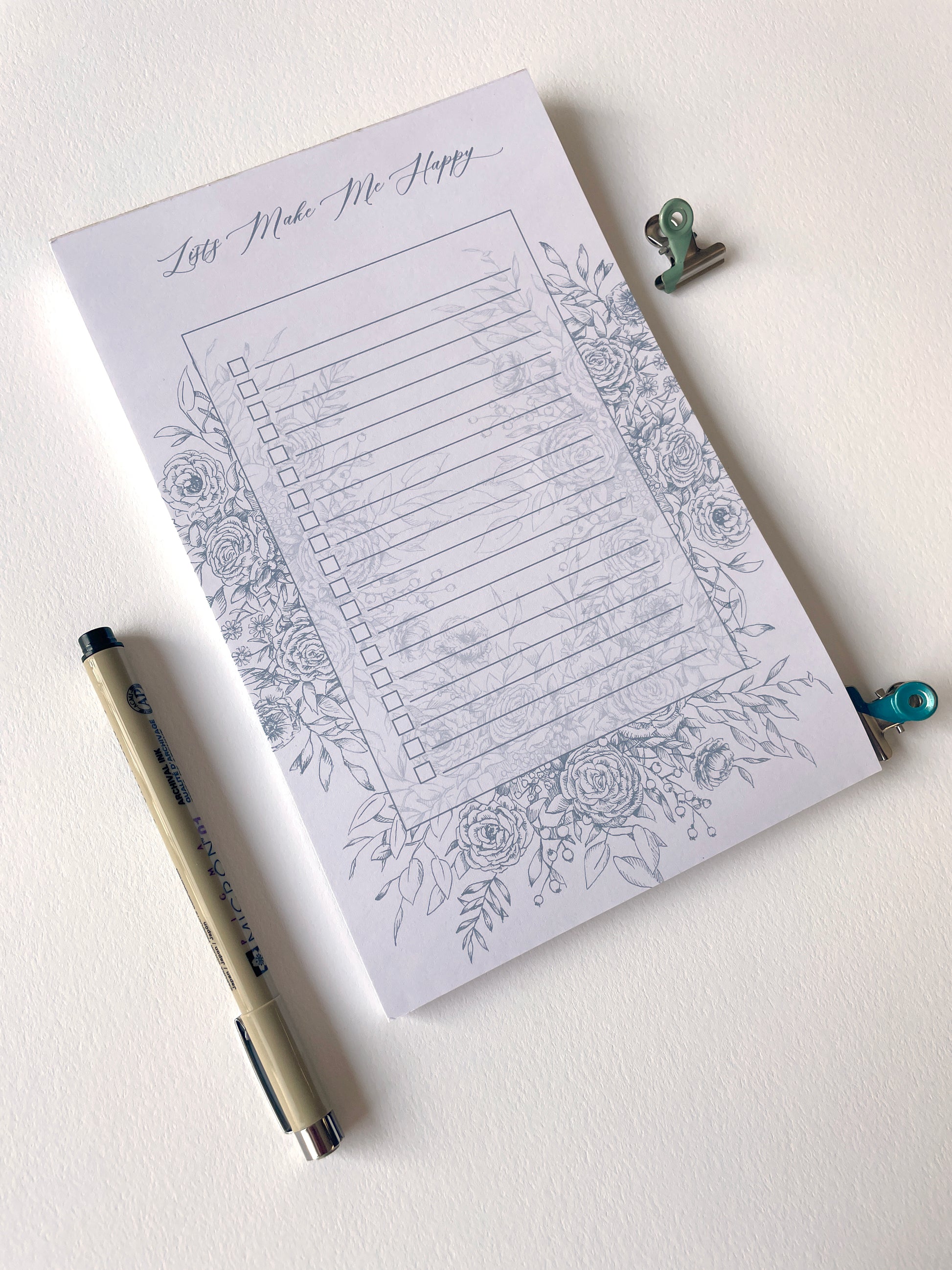 5.5 by 8.5 notepad with lined sheets with blue florals that says "Lists make me happy" by Rust Belt Love