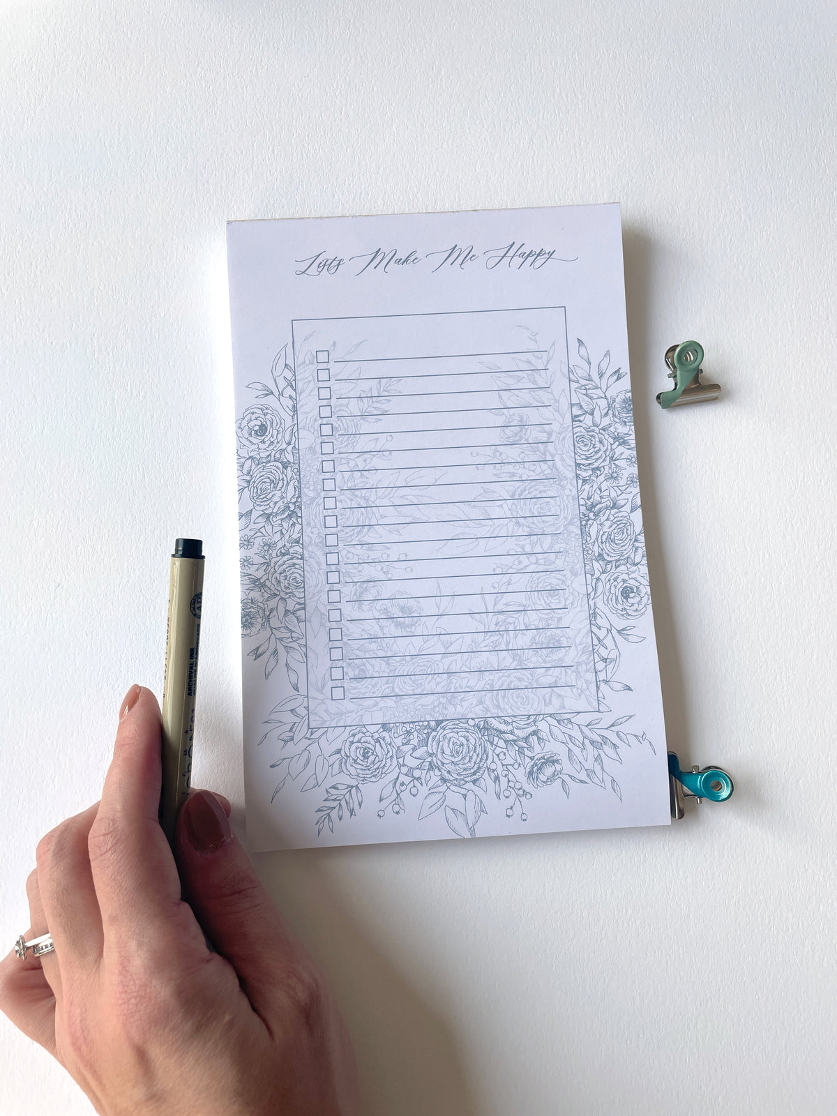 5.5 by 8.5 notepad with lined sheets with blue florals that says "Lists make me happy" by In Good Company