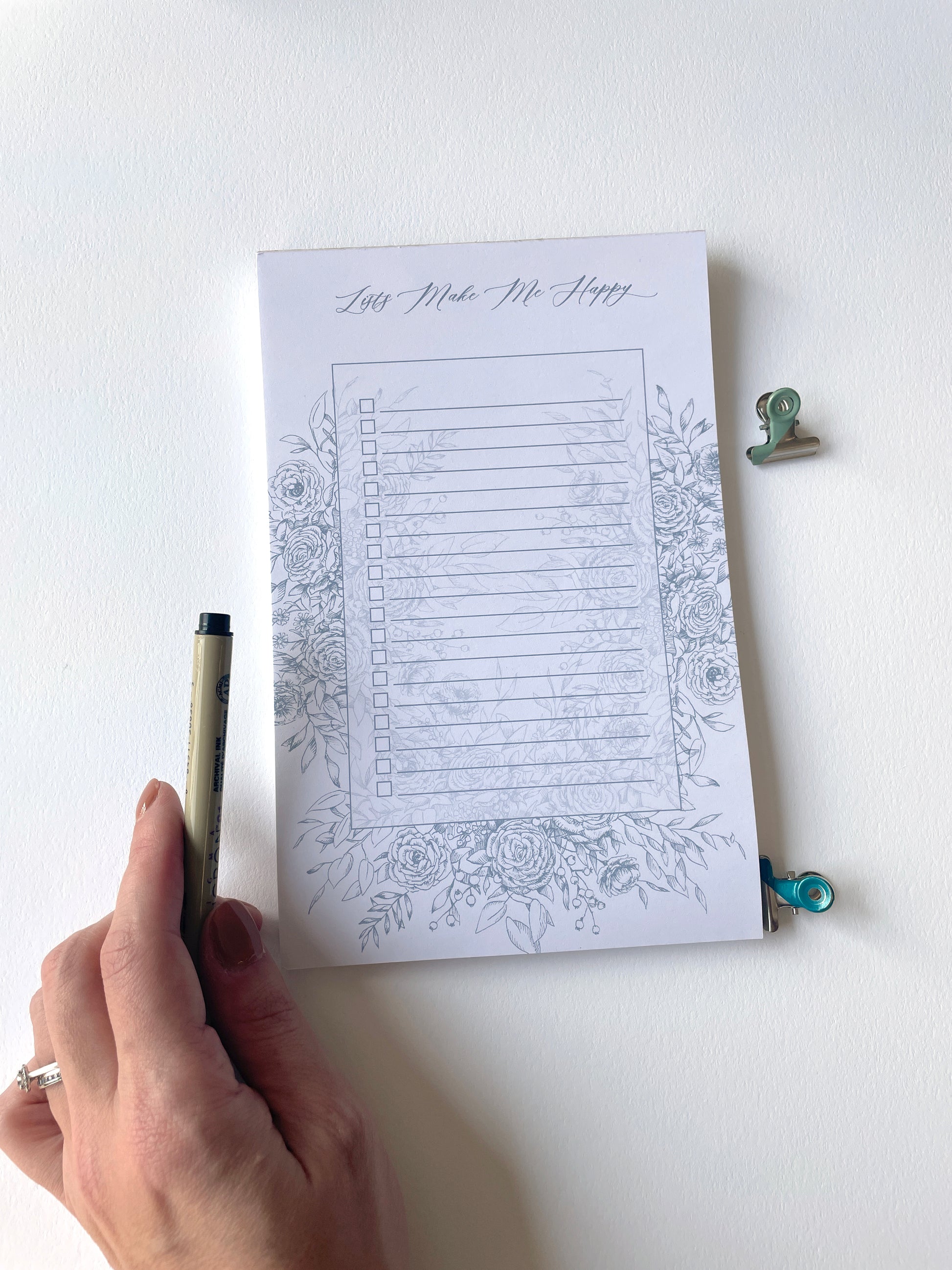 5.5 by 8.5 notepad with lined sheets with blue florals that says "Lists make me happy" by Rust Belt Love