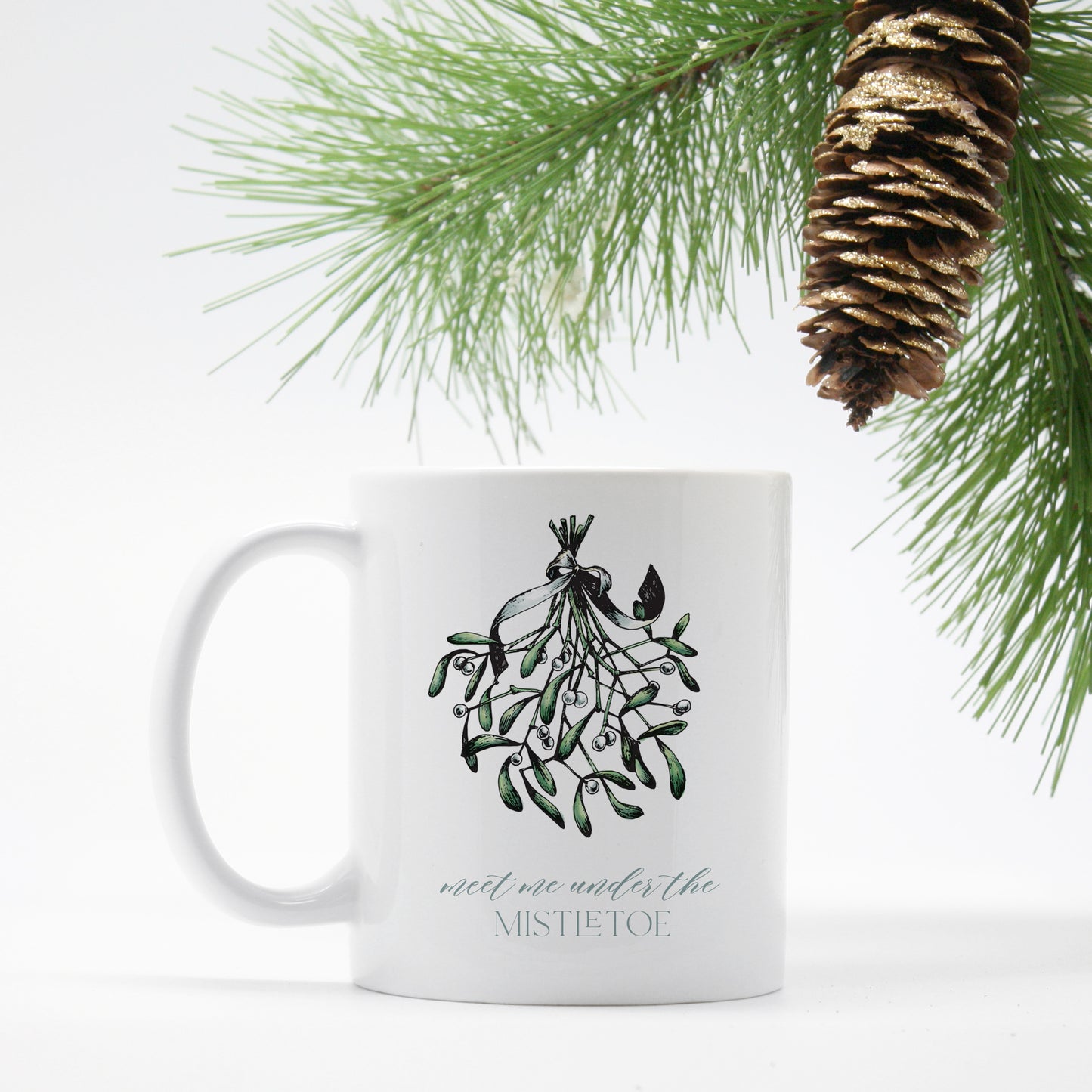 White ceramic mug with a mistletoe that says "meet me under the mistletoe by Rust Belt Love 